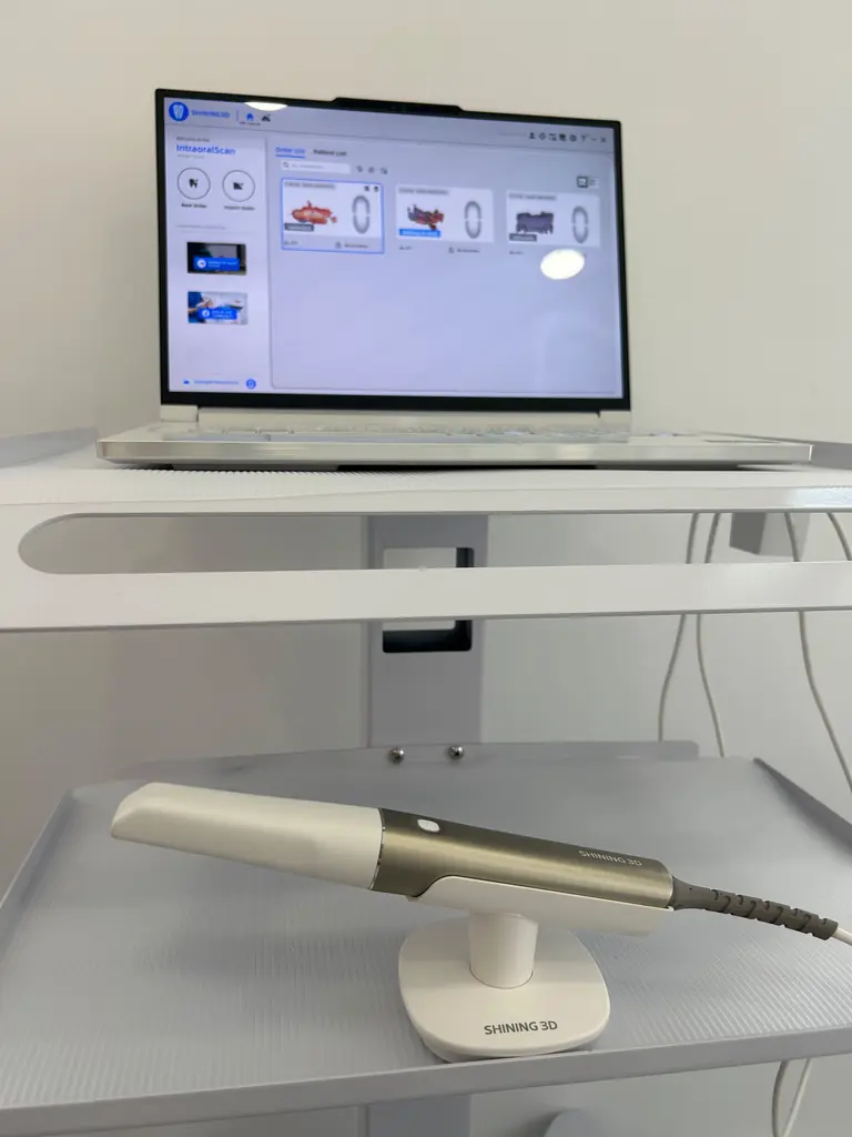Scaner intraoral Shining 3D lângă laptopul cu software-ul de scanare